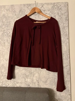 Vinröd långärmad tröja med knyt från lager 157 - Mysig vinröd tröja med långa ärmar och knytband vid halsen från lager 157, tröjan är aldrig använd och i storlek S