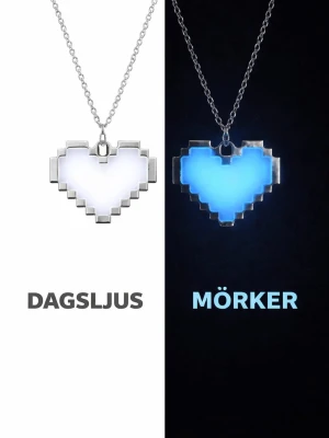 Pixelhjärta Glow in the dark hjärthalsband - Unikt halsband med ett pixelhjärta som lyser i mörkret. Hängsmycket är vitt i dagsljus och får en cool blå glow när det är mörkt. Kedjan och ramen är i silverfärgad metall och har en modern, kantig design. Perfekt accessoar för dig som gillar gaming eller retrostil. Kedjan är I rostfritt stål. Hänget börjar lysa i mörker efter att ha varit en kort stund i vanligt dagsljus. Lyser vanligtvis i flera timmar. 