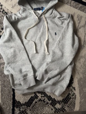Ralph laurent hoodie  - Grå hoodie med off white snören från polo ralph laurent. Tröjan är inte använd. Den är köpt för 1900.