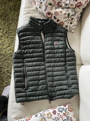 Mörkgrön dunväst från Colmae  - Säljer en skitsnygg mörkgrön väst från Colmar i storlek 50(M). Perfekt nu till våren. Den är i nytt skick och ingen effekter. Säljer på grund av att den börjar bli för liten. Hör av dig vid någon fråga. Skickar samma dag eller dagen efter!  