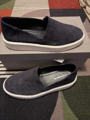 Vagabond loafer - Snygga svarta loafers från Vagabond i mocka med vit, tjock sula. Skorna har en stilren slip-on design och är perfekta för dig som gillar en enkel men trendig look. Insidan är fodrad i svart och märket syns tydligt på innersulan. Stora i storlek passar nog 42-43