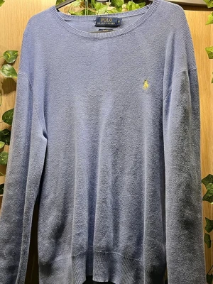 Ljusblå tröja från Polo Ralph Lauren - Klassisk ljusblå tröja från Polo Ralph Lauren med rund halsringning och den ikoniska gula logobrodyrn på bröstet. Tröjan har långa ärmar och ribbade muddar vid ärmslut och nederkant. Perfekt för en stilren och avslappnad look. Pris går även att diskuteras 😊🤩