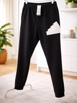 Svarta mjukisbyxor från Adidas - Säljer ett par svarta mjukisbyxor från Adidas med vit logga på ena benet. Byxorna har resår i midjan och muddar vid bensluten. Perfekta för chill dagar eller träning. Klassisk och avslappnad passform i mjukt material.