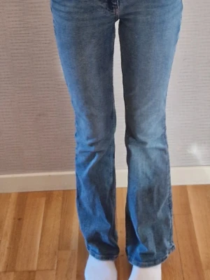 Blåa lågmidjade jeans - Ett par snygga blåa low waist flared/bootcut jeans från Gina Tricot. Dem är storlek XXS (32) tall. Passar mig som är ca 167cm. Säljer för att de inte kommer i användning men de är i väldigt fint skick. Mer bilder kan fås vid intresse! Nypris 499 SEK.☺️🌸