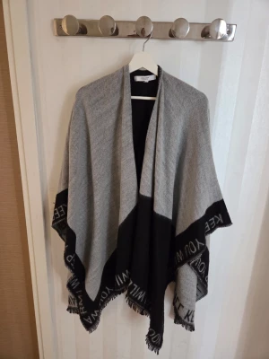 SOM NY Poncho från Vero Moda anv 1 g  - SOM NY Poncho från Vero Moda med texten I will keep you warm längs ytterkanten  ANV 1 G