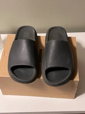 Yeezy slides - Tja, säljer ett par snygga Yeezy slides då de har blivit försmå för mig. Innan de skickas så gör jag rent de. De är liten i storleken så ni vet!
