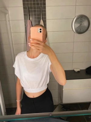 Vit croppad topp med resår - Snygg vit croppad topp med resår i midjan och korta ärmar. Använd några få gånger men den är i fint skick och har inga märkbara skavanker🌸 bara att skriva om du undrar nåt eller vill ha fler bilder eller mått