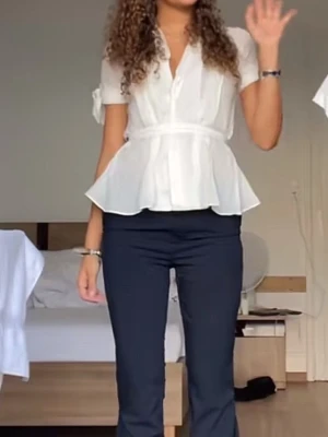 Vit peplumblus med knytärmar - Säljer en vit peplumblus med korta knytärmar och markerad midja. 