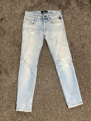 Replay Anbass Slim Fit Jeans – W29 L32 - 💥 Säljer mina Replay Anbass i storlek W29 L32. Ljusblå slim fit-jeans med snygga slitningar och klassiska fem fickor. 	•	Slim fit-passform 	•	Mjuk stretchig denim för skön komfort 	•	Perfekta för en avslappnad och trendig look  Säljes för 579kr – riktigt snygga jeans som passar både vardag och fest! 