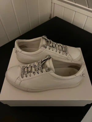 Givenchy sneakers - Snygga vita sneakers från Givenchy i läder. Skorna har vita snören med Givenchy-logga i svart. De passar både tjejer och killar. Allt på bilderna kommer med skorna. Så som Dustbag, skolåda och en liten lapp som visar att de är äkta. ALLT ÄR ORGINAL!