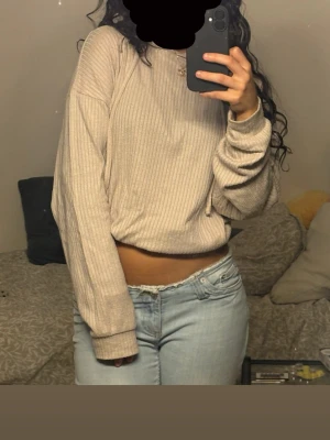 Beige ribbad croppad tröja 🤍 - Superfin och bekväm. Har snören längst ner som man kan dra åt för att göra tröjan kortare eller knyta en fin knut. Säljs då dne tyvärr ej kommer till användning. Bra skick.