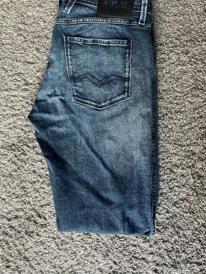Unika Replay anbass - Unika blåa replay jeans med vita tvättningar och slitningar. Jeansen är i bra skick. Storleken är 33/34 men skulle säga att dem passar mer 32/34. Hör av dig vid frågor eller prisförslag!