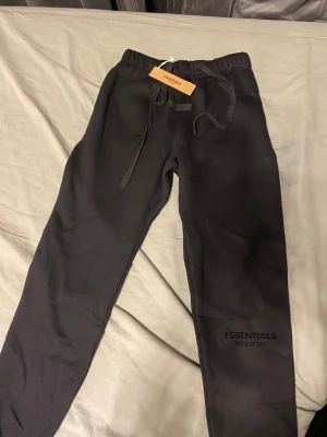 Svarta Essentials Fear of God sett - Säljer ett par svarta tracksuit från Essentials Fear of God linjen. Nästan helt ny aldrig använt bara testat på inga skador eller fläck. Storlek S.