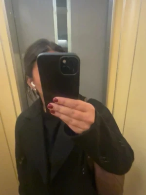 Svart kappa - Stilren svart kappa med knytskärp i midjan. Materialet är mjukt och bekvämt.