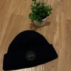 Svart mössa  - Säljer en svart ribbstickad mössa frånmed klassisk rund logotyp framtill. Mössan är enkel, stilren och passar perfekt till kyla.