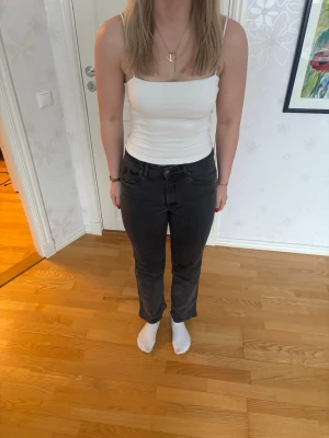 Svarta raka jeans från Lois - Säljer ett par svarta jeans från Lois med rak passform och hög midja köpta från Jeansspecialisten. Jeansen har klassisk femficksdesign och är tillverkade i ett mjukt denimtyg med stretch. Perfekta till en enkel topp eller hoodie. Jeansen ger retro vibe och är svartgrå färg och går ner till anklarna.