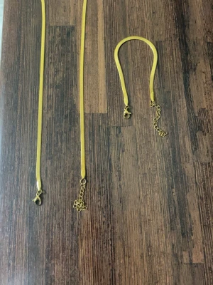 Guldigt halsband och armband  med kedjedetalj - Snyggt halsband och armband i guldfärgad metall med slät, platt kedja och justerbar längd. Enkel och stilren design som passar till många olika looks. Perfekt för dig som gillar minimalistiska accessoarer. Säljs eftersom det används aldrig det är rostfria så man kan duscha och göra allt me dom och priset går att diskutera