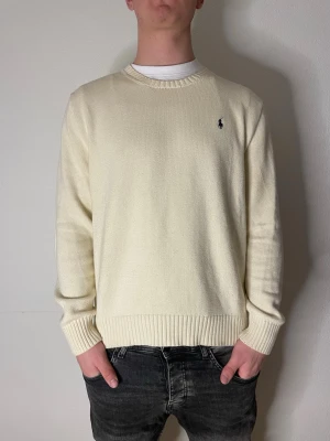 Biege stickad tröja från Ralph Lauren - Jag säljer en biege stickad Ralph lauren tröja. Modellen är 187cm och den är lite kort på honom. Finns en liten defekt på bild 4. Hör av er vid funderingar eller frågor!