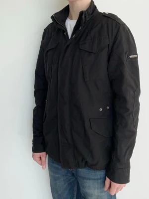 Woolrich Field Jacka - Snygg och eftertraktad field jacka från Woolrich! Fint skick inga defekter. Storlek M, modellen är ca 182, 70kg. Kontakta mig för fler frågor och funderingar!