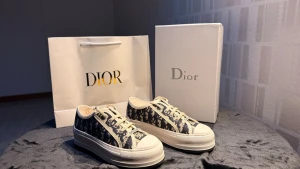 CD plattforms  låga sneakers - Snygga D plattform sneakers i lågt snitt med klassiskt blått och vitt monogrammönster. Skorna har vita snören, robust vit sula och detaljer i canvas och gummi. Perfekta för dig som vill ha en exklusiv och trendig look.