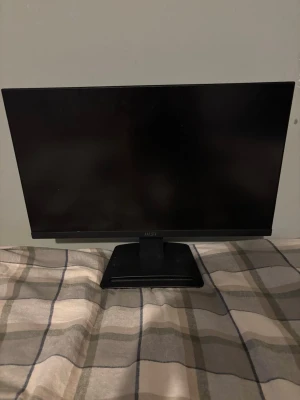 Svart MSI datorskärm - Säljer en stilren svart datorskärm från MSI med tunn ram och rektangulär fot. Skärmen har modern design och passar perfekt till gaming eller arbete. Tillverkad i plast med mattsvart finish och MSI-logga på framsidan. Den är 60 Hertz 