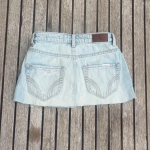 Ljusblå jeanskjol från Hollister  - Supersöt ljusblå jeanskjol från Hollister i storleken w24. Den är i gott skick men har ett litet hål längst fram! 