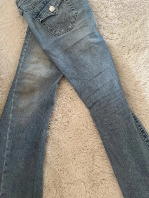  jeans från True Religion - blåa jeans från true religon i modell joey. storlek 26, säljer då dom inte används så ofta. har några defekter längst ner vid slutet av byxorna.