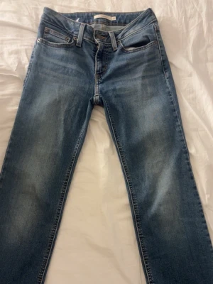 Blå raka jeans från Levi's - Klassiska blå jeans från Levi's med rak passform och fem fickor. Jeansen har en snygg tvättad look och är tillverkade i slitstarkt denim. Perfekta för en avslappnad stil och har den ikoniska röda Levi's-lappen på bakfickan. bilder på vid seriöst intresse!‼️‼️‼️‼️‼️‼️