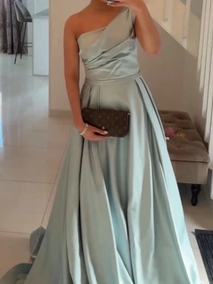 Ljusblå långklänning med oneshoulder - Säljer nu denna, den är i storlek 34-36, insydd. Även så var den köpt för 4999 och nu säljs för 3000 men pris kan diskuteras vid snabb affär. Använda enbart en kväll 🤍
