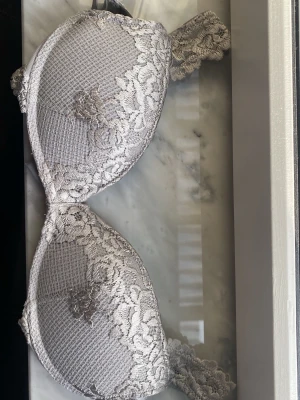 Intimissimi bh 70b - Snygg grå intimissimi bh, storlek 70b med vadderade kupor och vacker spets med blommönster. Axelbanden är dekorerade med spetsdetaljer! (Nypris: 520 kr) FRÅGA OM DU UNDRAR NÅGOT 💕💕