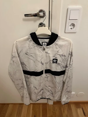 Adidas Originals Marble Jacka - Tunn jacka från Adidas Skateboarding (windbreaker)  Förpackningsbar i sin egen ficka. Använd en del men inga defekter vad jag kan se.  Storlek M