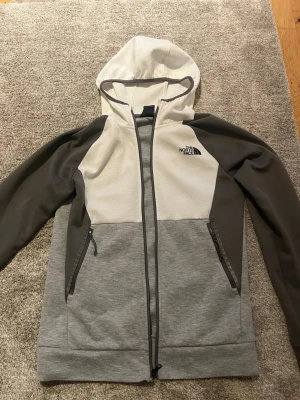 Grå hoodie från The North Face - Snygg hoodie från The North Face i grå vit färg. Använd 1 år. Jätte bra skick. Perfekt för våren!!!        Vid diskussion om pris kontakta!! Äkta!
