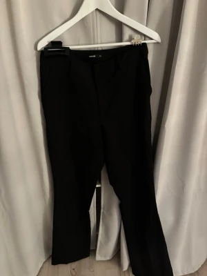 Svarta kostymbyxor från Bik bok - Snygga svarta kostymbyxor från bik bok med raka ben och pressveck med fickor fram och bak
