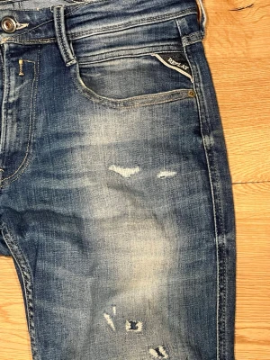 Replay Anbass Jeans - Riktigt snygga Replay jeans med lite schystare slitningar i modellen Anbass. Köpta på NK, näst intill oanvända och nyskick. Storlek 31/34🙌