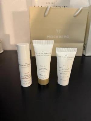 Rituals The Ritual of Namaste kit - Set med tre produkter från Rituals The Ritual of Namaste: Glow radiance anti-ageing serum, Purify cleansing foam och Glow radiance anti-ageing day cream. Alla i vita tuber med guld- och silverdetaljer. Perfekt för hudvård och glow.