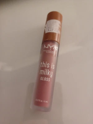 NYX This Is Milky Gloss Cherry Skimmed - NYX This Is Milky Gloss i färgen Cherry Skimmed är ett mjölkigt läppglans med en mjuk rosa-brun ton. Bara testad men aldrig använt annars.