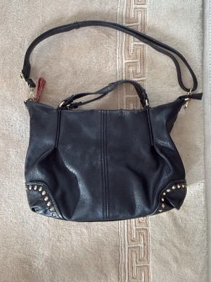 Svart handväska - Säljer denna väska eftersom den inte kommer till användning. Har slitet läder här och där 