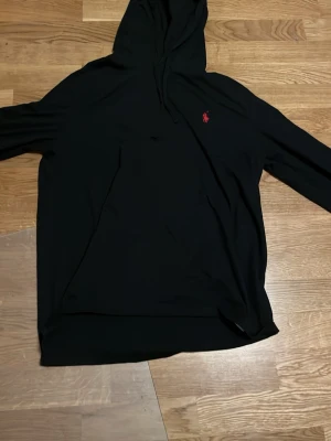 Svart hoodie från Polo Ralph Lauren - Svart hoodie från Polo Ralph Lauren. Nästan som ny använd få tal gånger och säljer den pågrund av att jag inte använder den längre. Fraktar inom 24timmar 