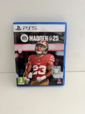 Madden NFL 25 till PS5 - Madden NFL 25 till PlayStation 5, amerikansk fotbollsspel från EA Sports. Spelet kommer i ett blått plastfodral med omslag i svart, rött och vitt. Skivan har samma motiv som omslaget och är anpassad för PS5. Använd men i mycket gott skick