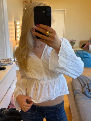 Vit broderad blus med volangärm - Superfin vit blus med broderade detaljer och volangärmar. Blusen har v-ringning och markerad midja som ger en snygg siluett. Perfekt för vår och sommar, passar till både jeans och kjol🪽🙌
