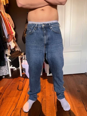 Blå raka jeans från weekday - Säljer ett par klassiska blå jeans från Ralph Lauren med rak passform och fem fickor. Jeansen har normal midja och är gjorda i ett slitstarkt denimtyg. Perfekta för en avslappnad och stilren look.