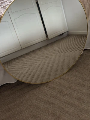 Rund spegel med tunn guldram - Säljer en stor rund spegel med tunn guldfärgad ram. Spegeln har en minimalistisk och modern design som passar perfekt i sovrum eller hall. Glaset ger en klar reflektion och ramen är diskret men ger ändå en lyxig känsla.