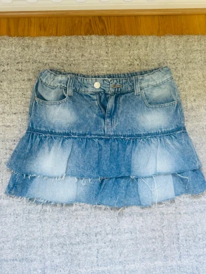Blå jeanskjol med volanger - Säljer en kort jeanskjol i blå denim med två lager volanger. Perfekt nu till sommaren❣️❣️❣️