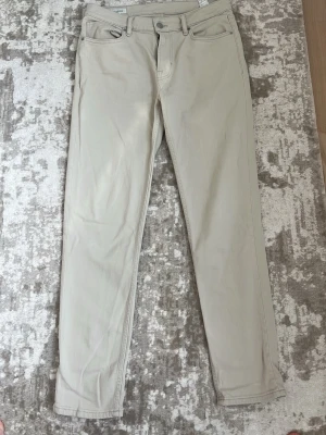 Beiga jeans - Beiga jeans från Zara stängs med knapp och dragkedja. Perfekta för en clean och stilren look. skulle säga att de är en blandning mellan storlek S/M i midjan. Längd 32 