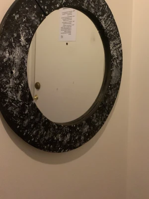 Rund spegel med svart ram - Säljer en rund spegel med bred svart ram som har ett marmorerat mönster i vitt och grått. Spegeln har en modern och unik design som passar perfekt som inredningsdetalj i hallen eller sovrummet. Ramen är troligtvis tillverkad av trä eller kompositmaterial. Ni kan även måla om den den var brun Inan målade om den till svart 