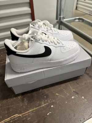 Nike Air Force 1 '07 Vit/Svart strl41 - Helt nya oanvända Nike Air Force 1 '07 Vit/Svart strl41. Skorna har inte blivit använda eller testade.  Original kartong medföljer  Nypris hos Nike 1400 kr