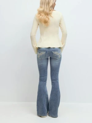 Blå bootcut jeans med broderade fickor - Snygga blå bootcut jeans med broderade detaljer på bakfickorna. Jeansen har en klassisk femficksdesign och lätt tvättad look. Perfekta för dig som gillar en retrostil med utsvängda ben.