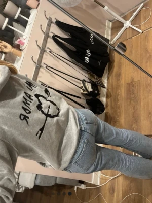 Grå hoodie med tryck - Säljer en grå hoodie med svart tryck framtill och texten 'IN AMOR'. Hoodien har huva med dragsko och en stor magficka. Tillverkad i mjukt sweatshirtmaterial, perfekt för chill dagar.