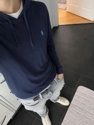 Polo Ralph lauren Hoodie (tunn) - storlek XL (L) - Säljer denna snygga polo Ralph lauren hoodie I tunt t-shirt material perfekt till sommaren!🤩  Den är i mycket bra skick borstet från de två väldigt små hålen i ryggen (se sista bilden). Inget som syns när tröjan är på.  Den är i storlek XL men skulle säga att den är mer åt L storleken.   Mått: B-40 cm L-68 cm  Priset är diskutabelt vid snabb affär   Fråga vid funderingar:) Skickas snabbt📦  Ps: kika in min profil för andra snygga kläder eller följ mig för kommande artiklar!😉