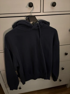 Mörkblå hoodie - En mörkblå hoodie med huva. Köpt på lager 157 och är i storlek S. Är i väldigt fint skick. 